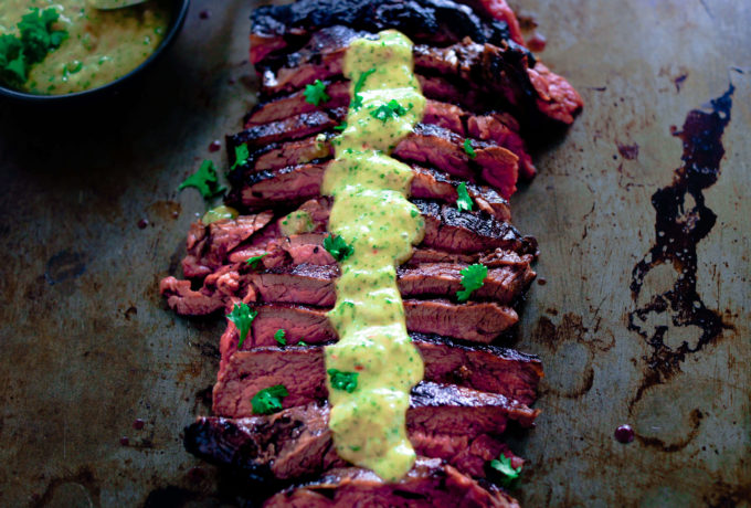Thinly slices skirt steak with chimichurri over the top