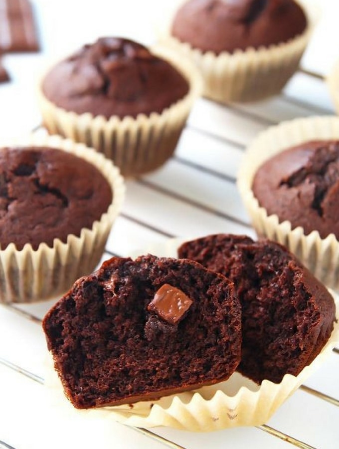 Warm chocolate coconut flour muffins on a steel cooling rack.