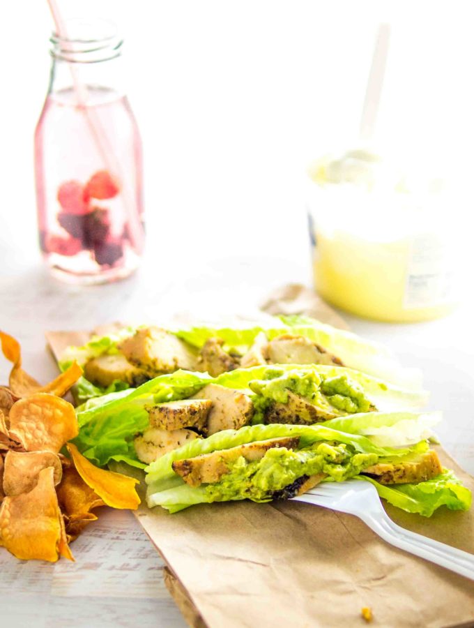 flame grilled chicken chopped on small romain lettuce boats topped with guacamole, with a side of sweet potato chips a drink with berries and lemon curd yogurt.